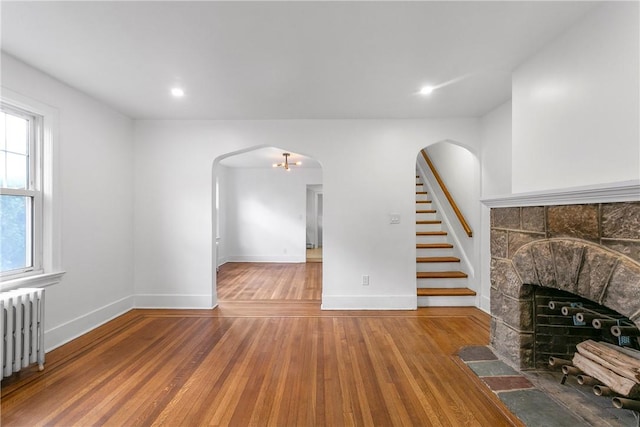 living room featuring wood-type flooring, a fireplace, and radiator