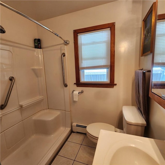 bathroom with a shower, a baseboard heating unit, tile patterned floors, sink, and toilet