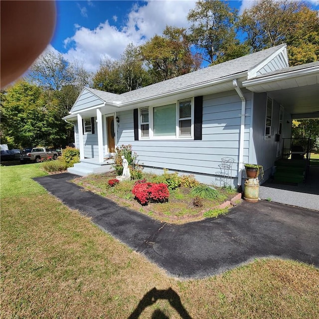 single story home with a front lawn and a carport