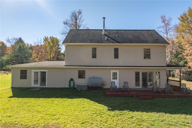 rear view of property featuring a deck and a yard