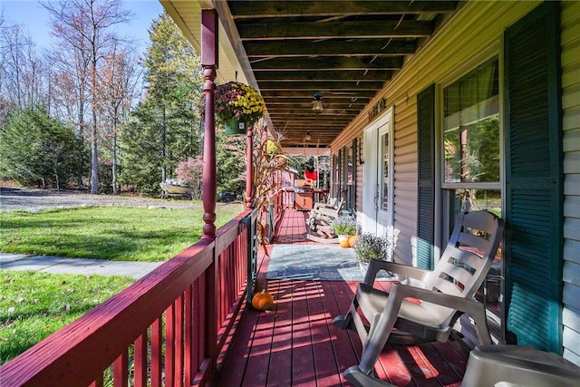 wooden deck with covered porch and a yard