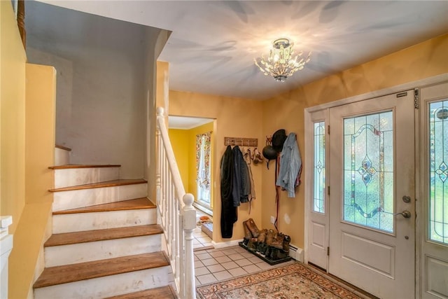 entrance foyer with a notable chandelier, light tile patterned floors, and a wealth of natural light