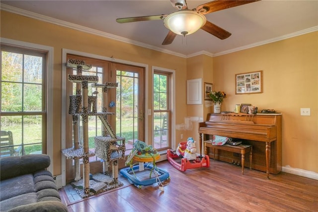 interior space featuring ornamental molding, hardwood / wood-style flooring, ceiling fan, and a healthy amount of sunlight