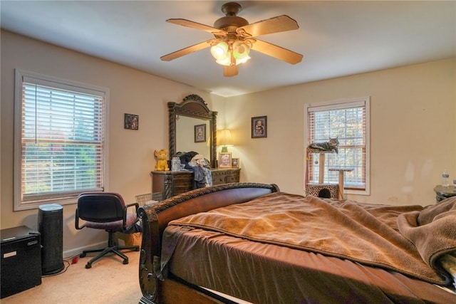 carpeted bedroom featuring multiple windows and ceiling fan