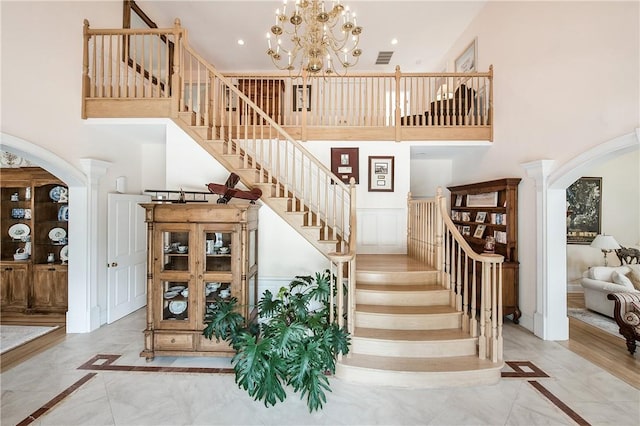 staircase featuring a chandelier and a towering ceiling