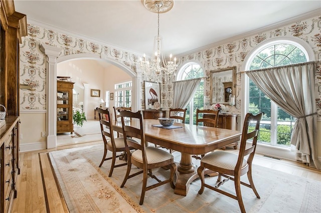 dining space with light wood-type flooring, crown molding, and a healthy amount of sunlight