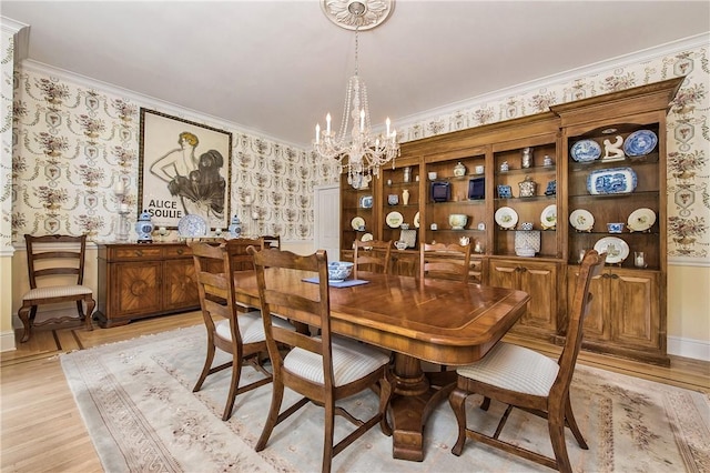 dining room featuring crown molding, a chandelier, and light wood-type flooring