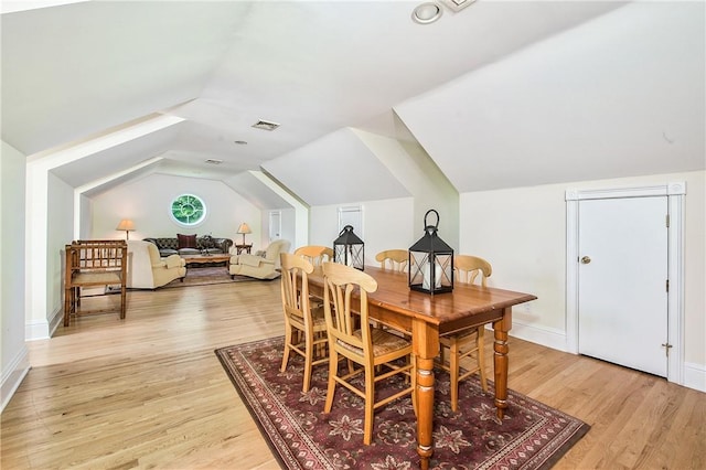 dining room featuring light hardwood / wood-style floors and lofted ceiling