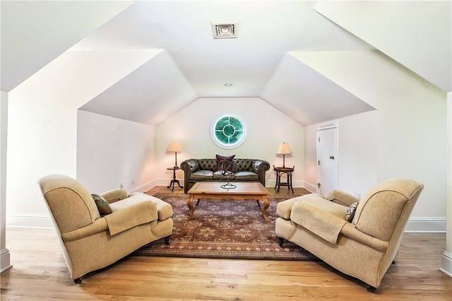 living room featuring light hardwood / wood-style floors and vaulted ceiling