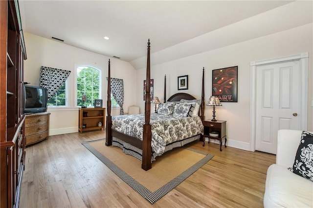 bedroom featuring lofted ceiling and light wood-type flooring