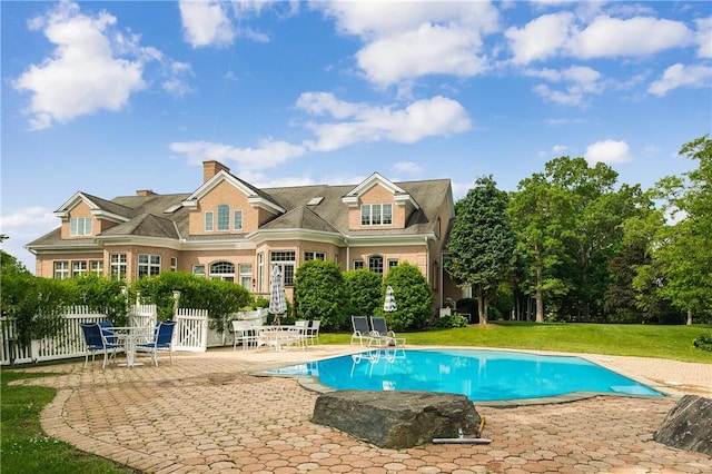 view of pool featuring a lawn and a patio area