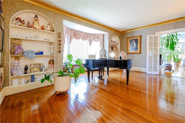 misc room featuring built in shelves, hardwood / wood-style floors, plenty of natural light, and ornamental molding