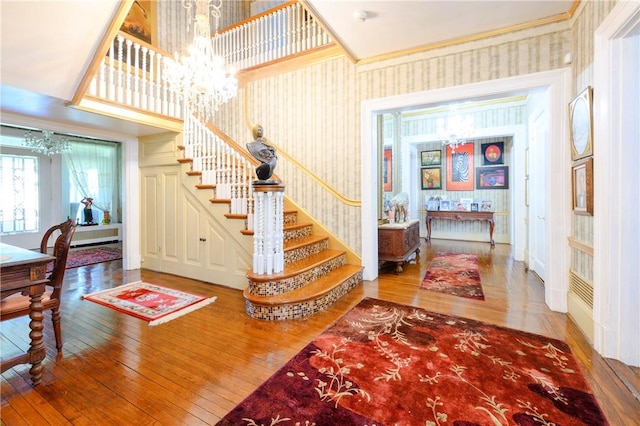 stairs with a chandelier and hardwood / wood-style flooring