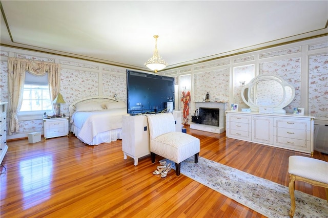 bedroom with hardwood / wood-style floors and crown molding