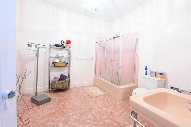 full bathroom with crown molding, sink, bath / shower combo with glass door, and toilet