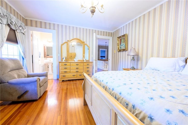 bedroom featuring ensuite bath, light hardwood / wood-style flooring, a chandelier, and ornamental molding