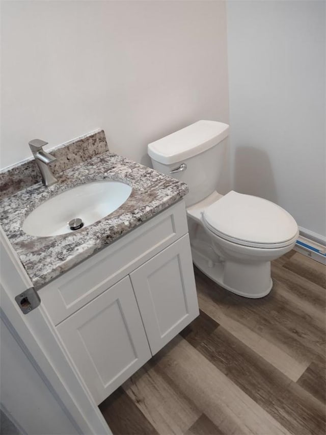 bathroom featuring hardwood / wood-style flooring, vanity, and toilet