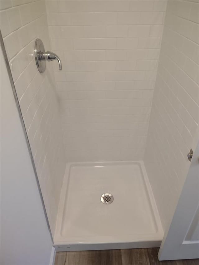 room details featuring hardwood / wood-style flooring and tiled shower