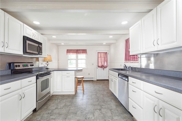 kitchen featuring white cabinets, appliances with stainless steel finishes, kitchen peninsula, and sink