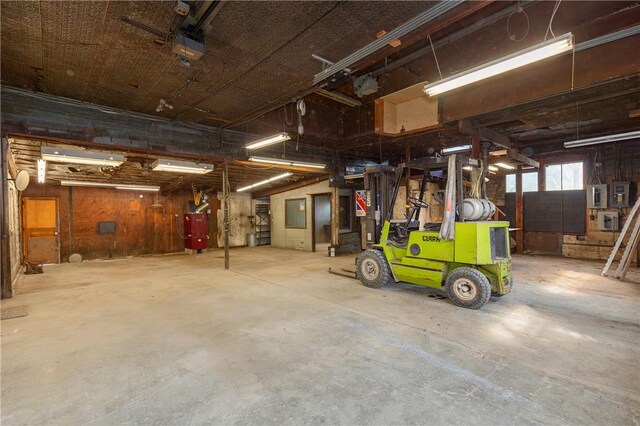 garage with wood walls and water heater