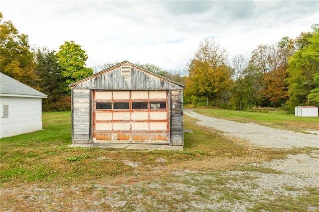 view of outdoor structure with a garage and a lawn