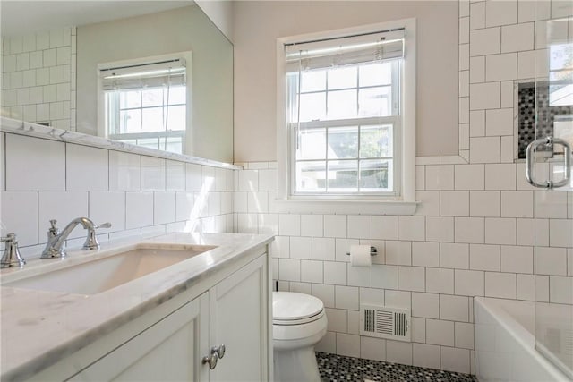 full bathroom with a healthy amount of sunlight and tile walls