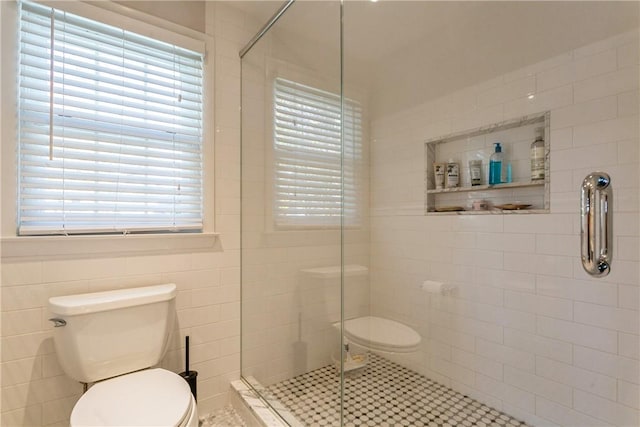 bathroom featuring toilet, tile walls, and walk in shower