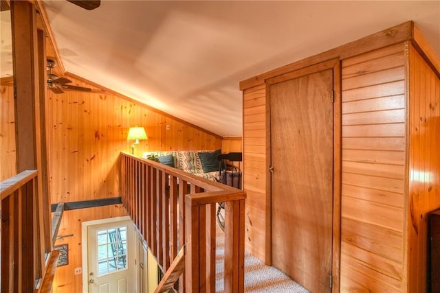 bonus room with ceiling fan, wooden walls, and vaulted ceiling