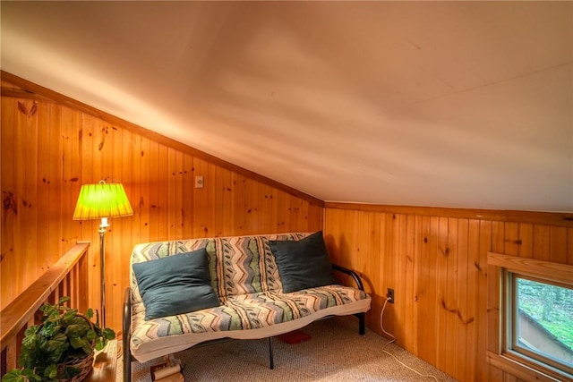 sitting room with carpet, wood walls, and lofted ceiling