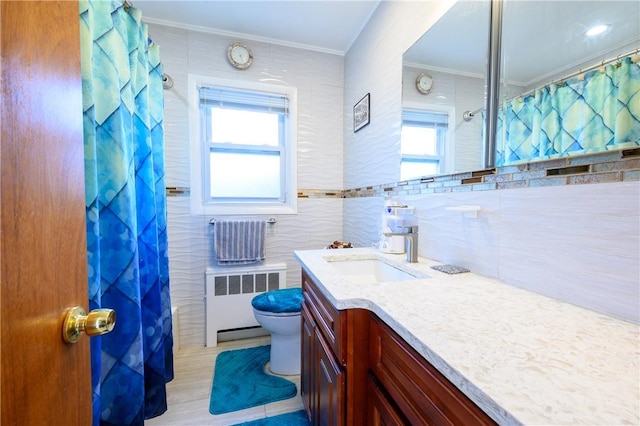 bathroom featuring plenty of natural light, vanity, tile walls, and radiator