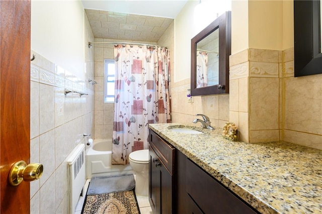 full bathroom featuring radiator, tile patterned floors, toilet, vanity, and tile walls