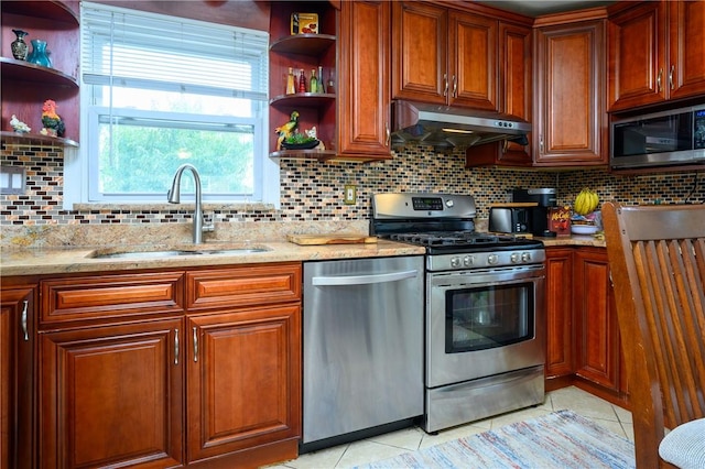 kitchen featuring light stone countertops, sink, stainless steel appliances, backsplash, and light tile patterned floors