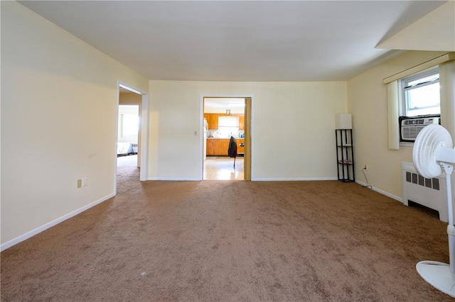 unfurnished room featuring cooling unit, radiator, and carpet floors