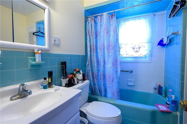 full bathroom featuring shower / tub combo, vanity, toilet, and tile walls