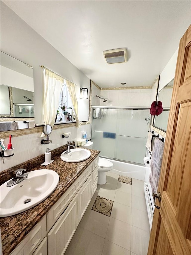 full bathroom with tile patterned flooring, toilet, combined bath / shower with glass door, and vanity