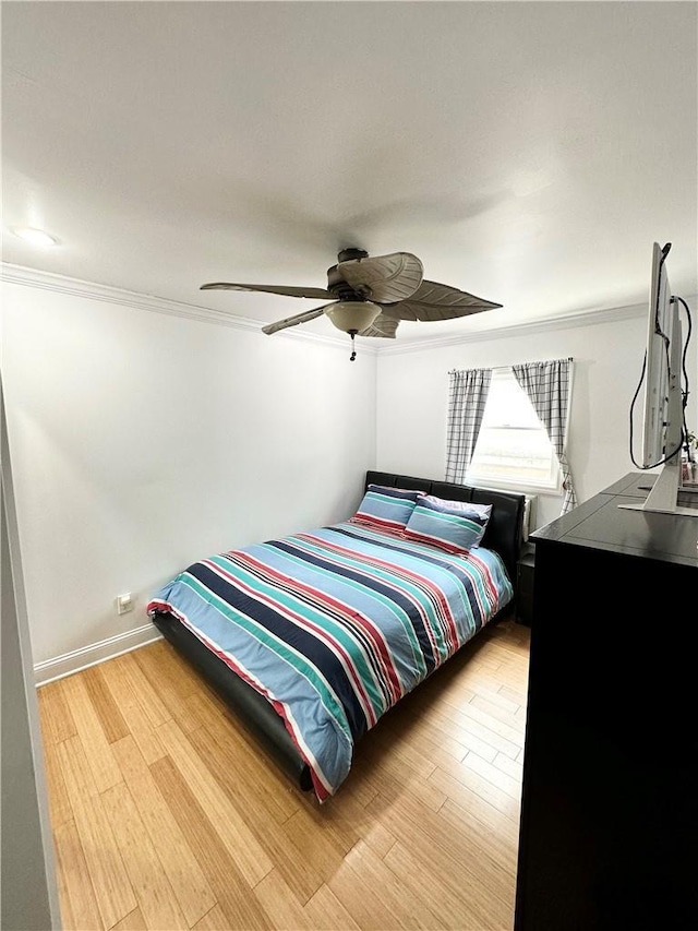 bedroom featuring hardwood / wood-style flooring, ceiling fan, and ornamental molding