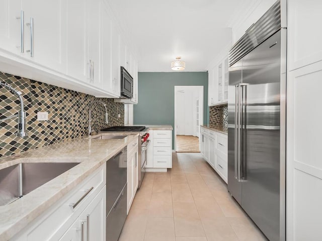 kitchen featuring white cabinets, sink, black dishwasher, and built in refrigerator