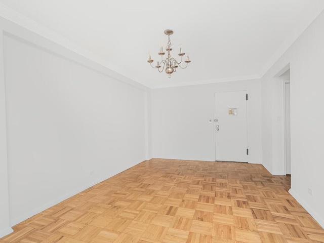 spare room featuring an inviting chandelier and light parquet flooring