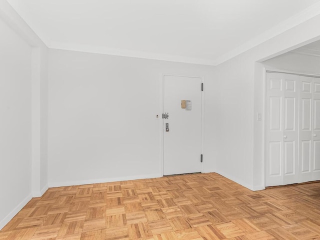 empty room featuring light parquet floors and crown molding