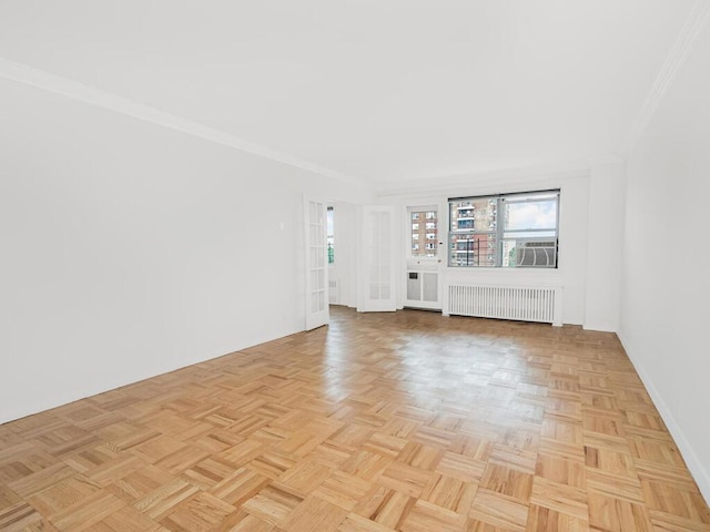 unfurnished living room featuring crown molding, radiator heating unit, and light parquet floors