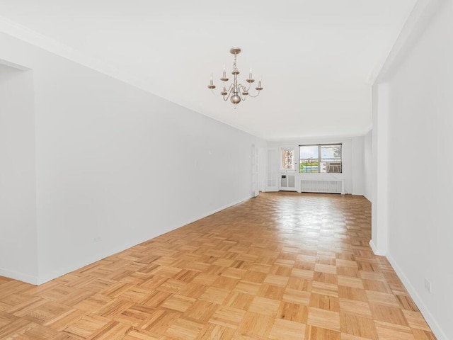 unfurnished living room featuring crown molding, radiator heating unit, light parquet flooring, and a notable chandelier