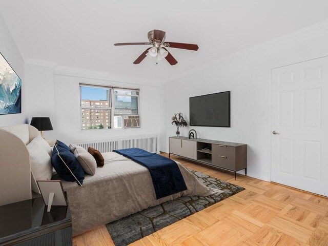 bedroom with ceiling fan, radiator heating unit, ornamental molding, and light parquet flooring