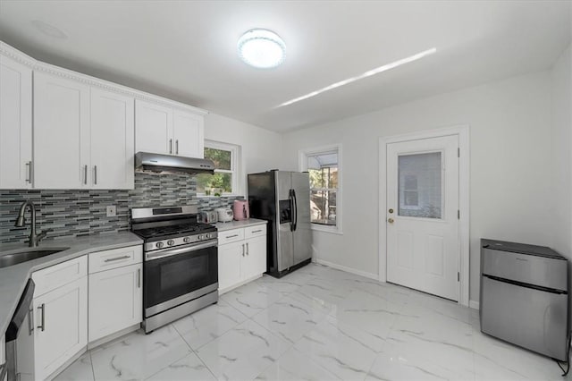 kitchen with tasteful backsplash, white cabinetry, sink, and appliances with stainless steel finishes