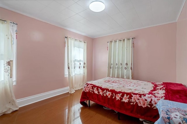 bedroom featuring wood-type flooring and ornamental molding