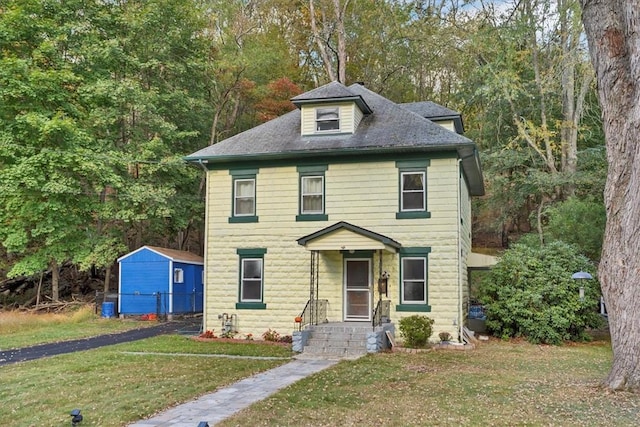 view of front of house featuring a storage shed and a front yard