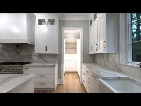 kitchen with backsplash, light stone countertops, sink, and white cabinets