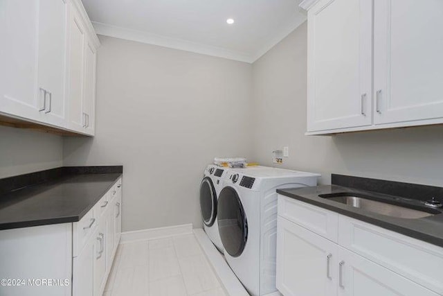 clothes washing area featuring cabinets, sink, crown molding, and washing machine and clothes dryer