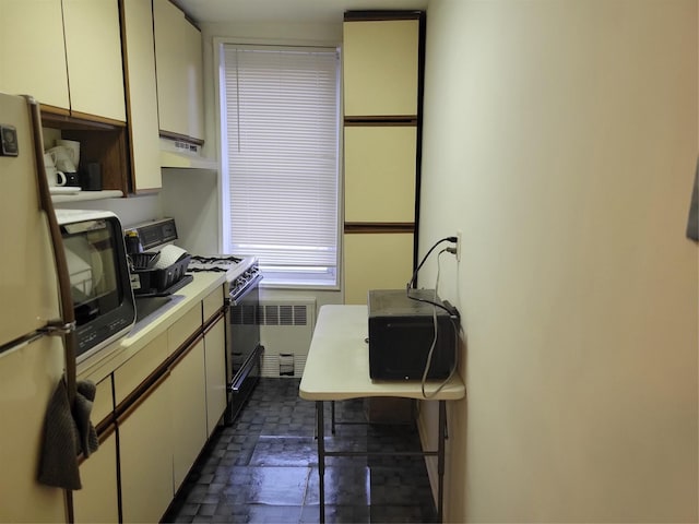 245 Rumsey Rd Unit 7B, Yonkers, NY 10701 - kitchen featuring radiator heating unit, black appliances, under cabinet range hood, light countertops, and an office area