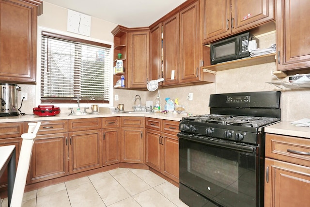 kitchen featuring black appliances, decorative backsplash, light tile patterned floors, and sink