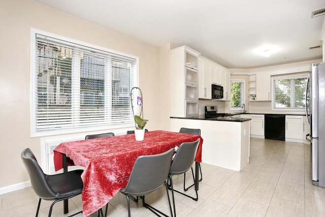 kitchen featuring white cabinetry, light hardwood / wood-style flooring, and black appliances